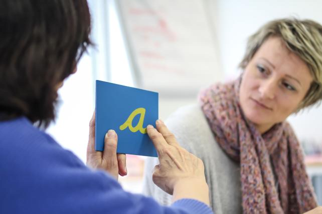 Trainer demonstrating tracing a sandpaper letter