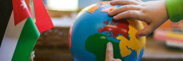 Children pointing at countries on a globe